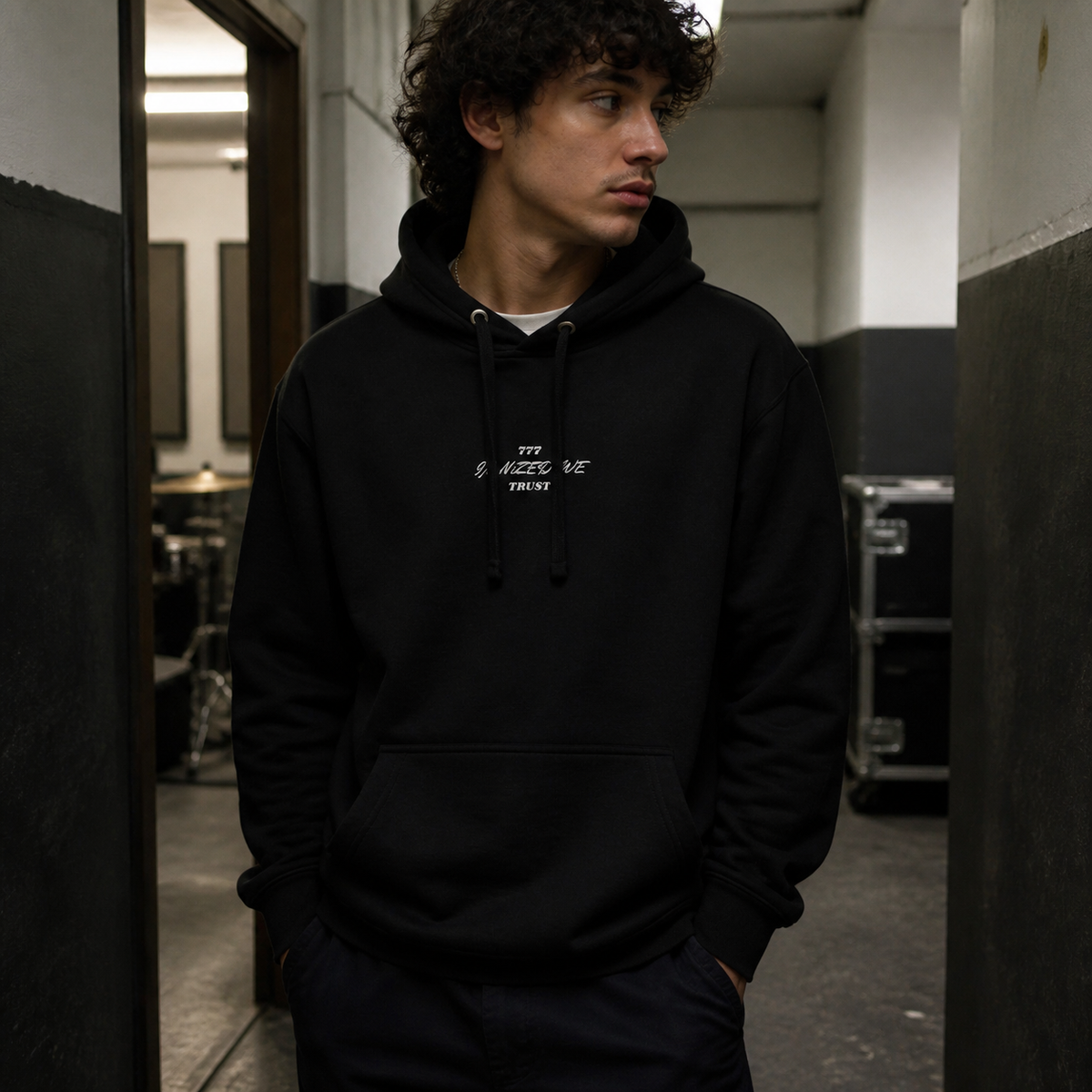Männliches Model im schwarzen NiZED 777 Graphic Hoodie mit kleinem Textprint in Berlin – KI-generierte Darstellung