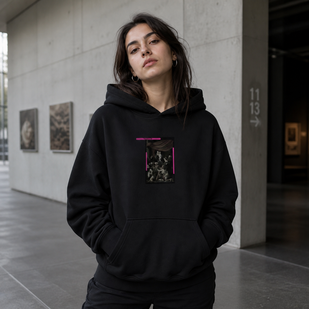 Weibliches Model trägt den schwarzen Divine Spirit Hoodie von NiZED mit klassischem Frontmotiv und pinken Details – KI-generierte Darstellung