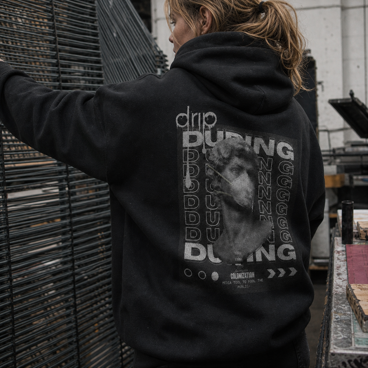 Drip Graphic Hoodie am weiblichen Model mit Backprint in einer Berliner Siebdruckwerkstatt – KI-generierte Darstellung