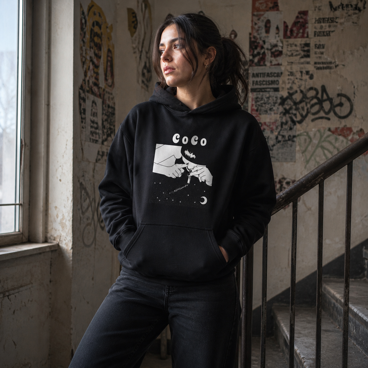 La Noche Graphic Hoodie am weiblichen Model mit Frontprint im Berliner Atelier-Treppenhaus – KI-generierte Darstellung