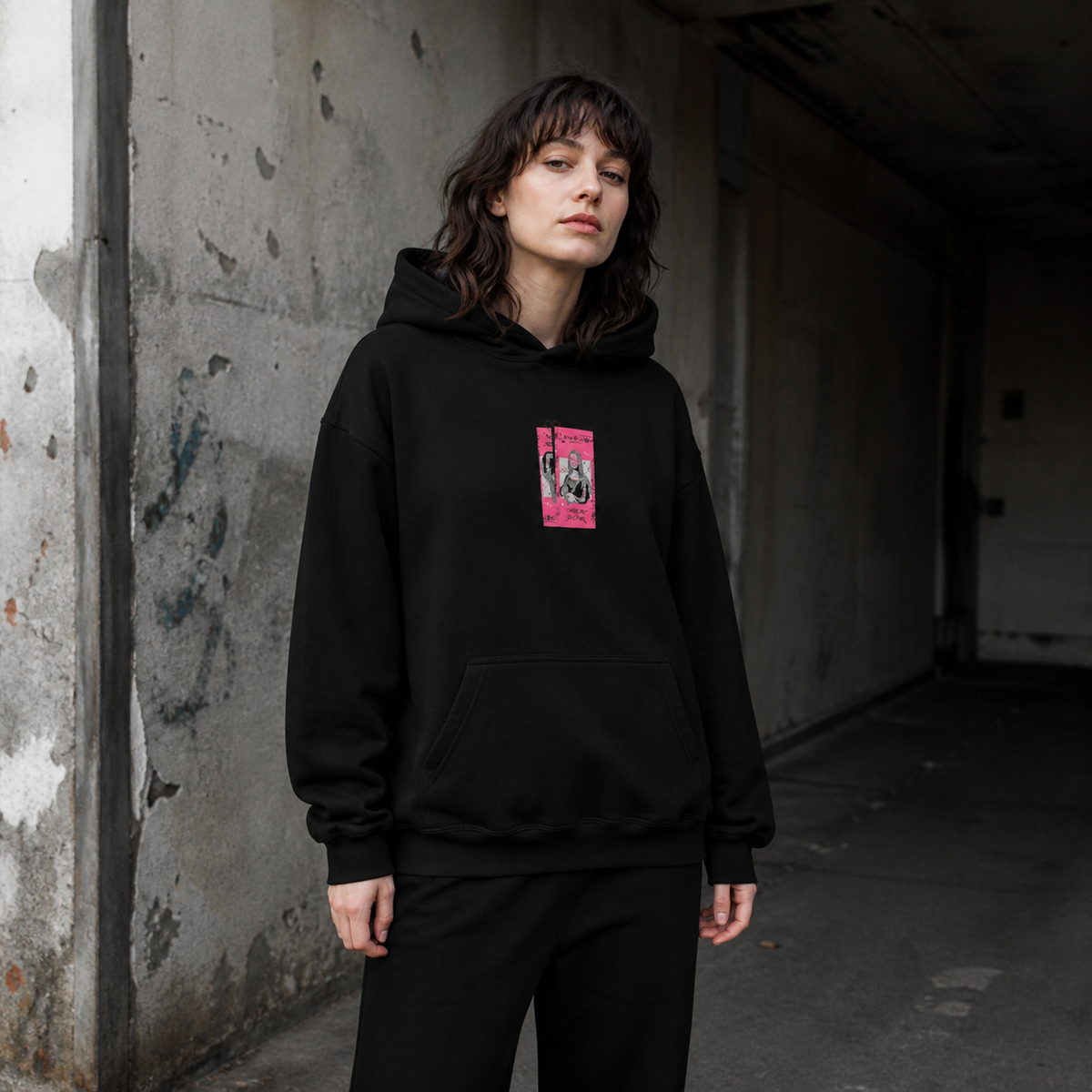 Weibliches Model im schwarzen Mon Cee Hoodie von NiZED mit kleinem pinkem Frontprint – KI-generierte Darstellung
