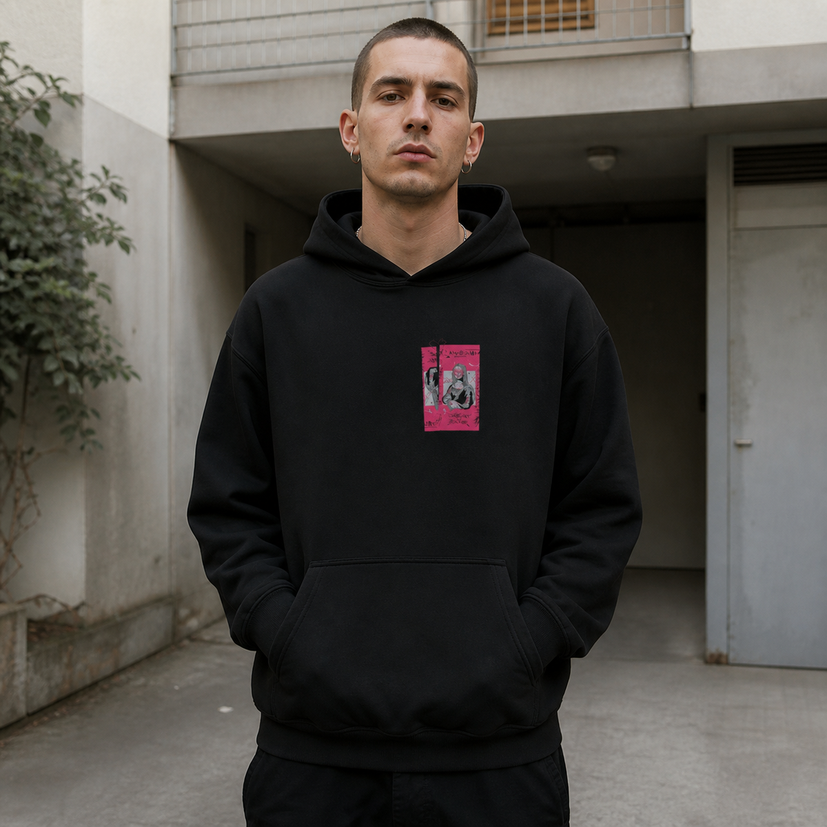 Männliches Model im schwarzen Mon Cee Hoodie von NiZED mit kleinem pinkem Frontprint – KI-generierte Darstellung