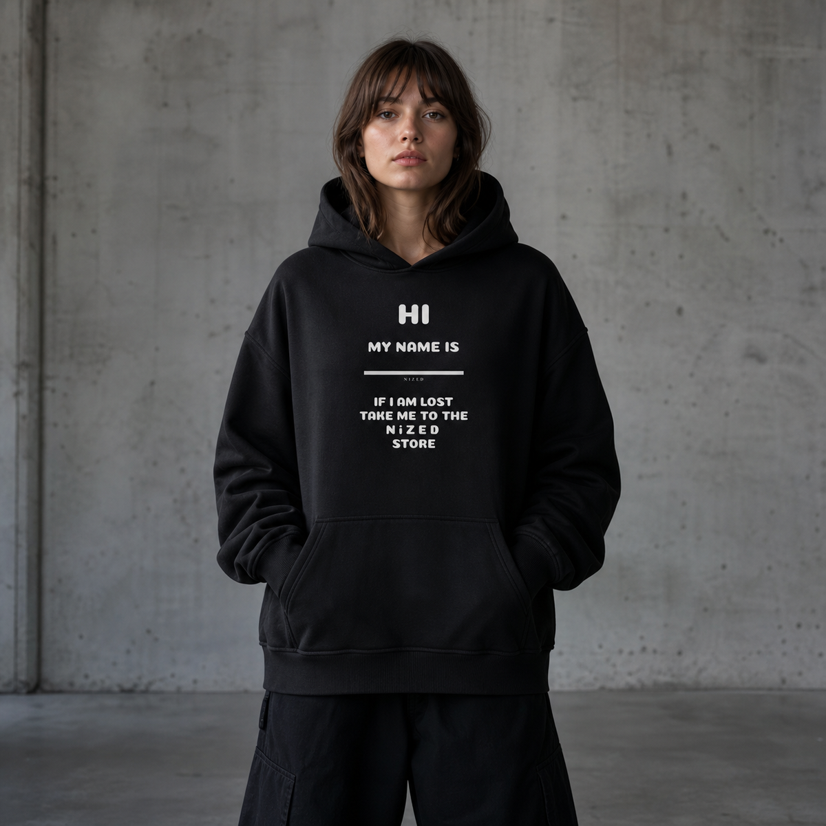 Weibliches Model im schwarzen Name Graphic Hoodie von NiZED mit weißem DTG-Schriftprint – KI-generierte Darstellung