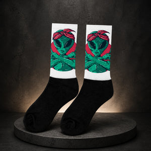 Alien Statement Socken – Paar auf dunklem Betonhintergrund