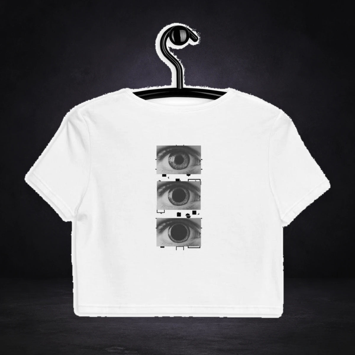 All Eyez On Me Crop Top von NiZED, Vorderansicht mit Designprint vor dunklem Betonhintergrund