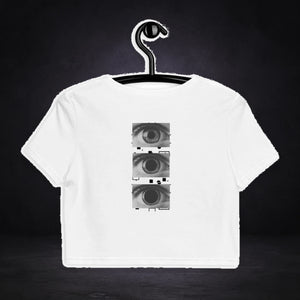All Eyez On Me Crop Top von NiZED, Vorderansicht mit Designprint vor dunklem Betonhintergrund