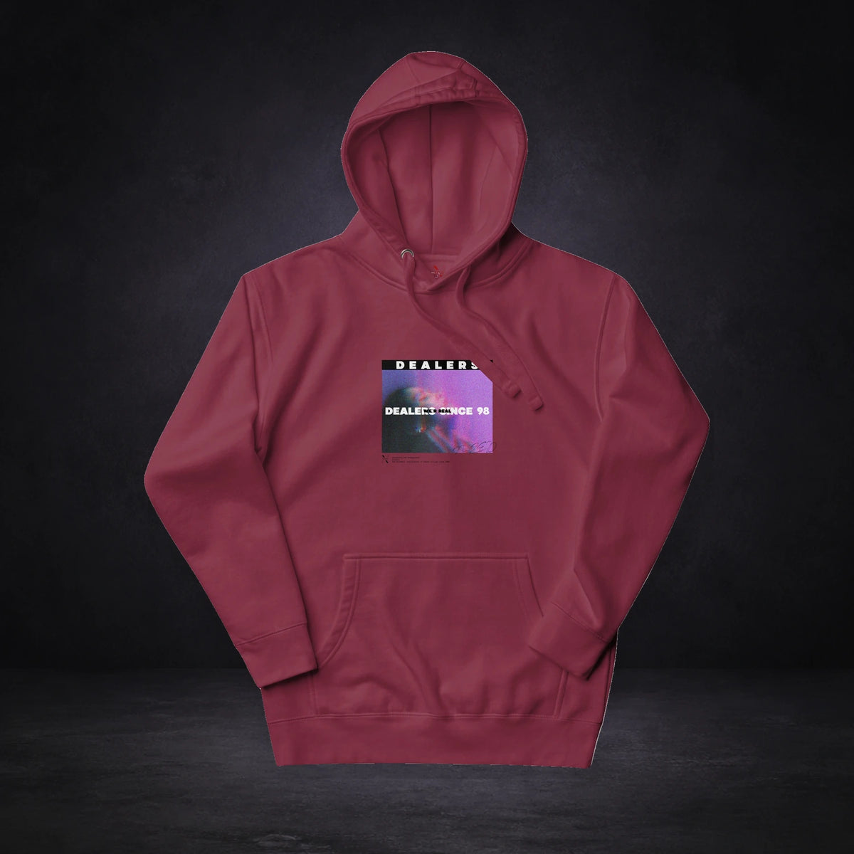 Dealers Graphic Hoodie Design 2 von NiZED, Vorderansicht mit Designprint vor dunklem Betonhintergrund