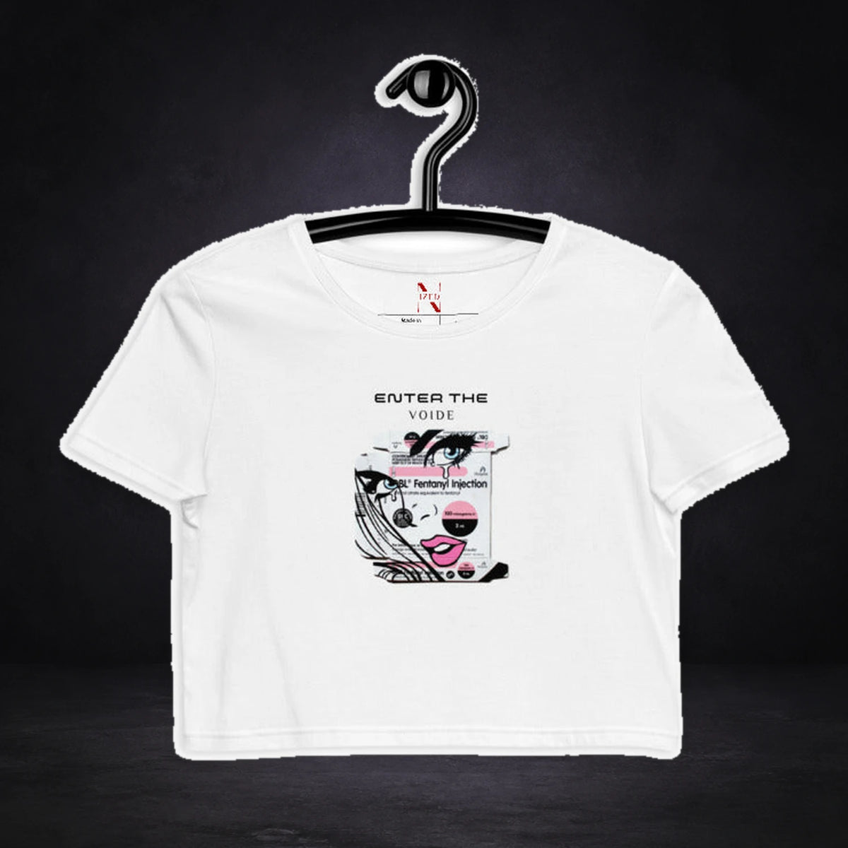 Enter Voide Crop Top von NiZED, Vorderansicht mit Designprint vor dunklem Betonhintergrund