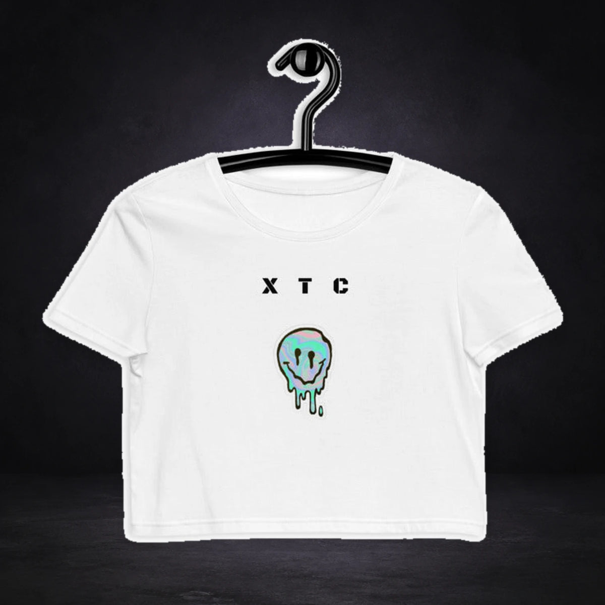 Extasy Vibes Crop Top von NiZED, Vorderansicht mit Designprint vor dunklem Betonhintergrund