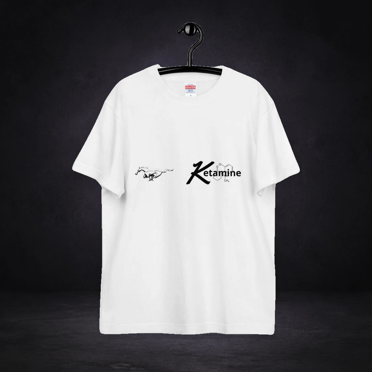 Ketamine Graphic T-Shirt von NiZED, Vorderansicht mit Designprint vor dunklem Betonhintergrund