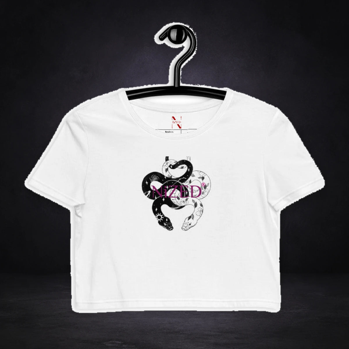 Snake Crop Top von NiZED, Vorderansicht mit Designprint vor dunklem Betonhintergrund