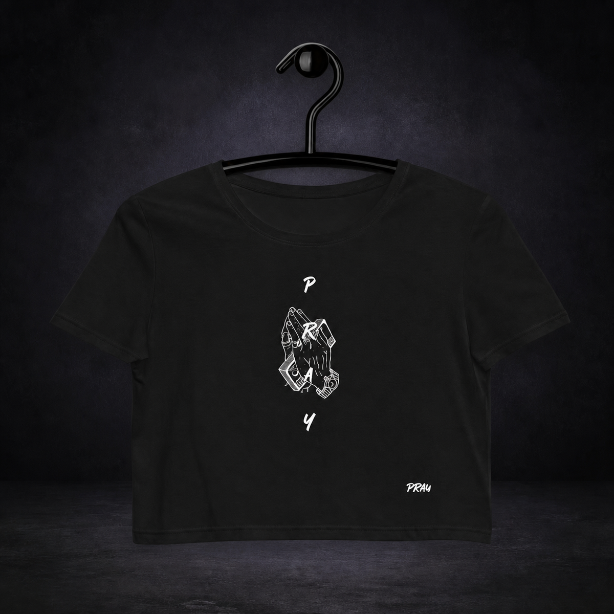 Pray Graphic Crop Top – schwarzes Crop Top ohne Freistellungskontur auf dunklem Betonhintergrund