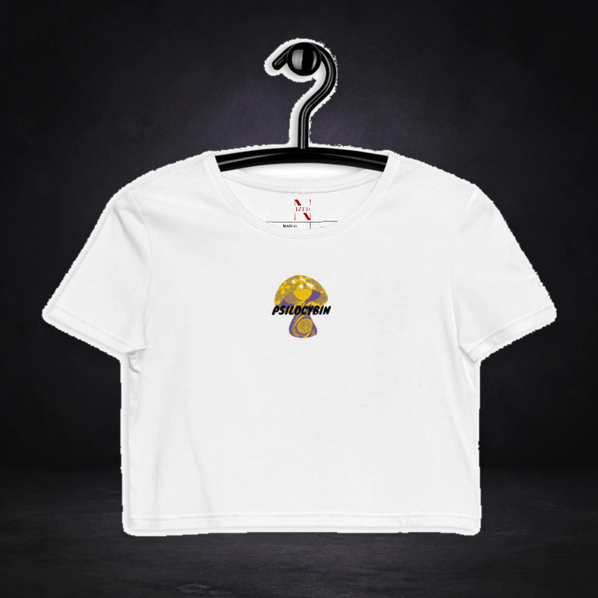 Psilocybin Bio Crop Top von NiZED, Vorderansicht mit Designprint vor dunklem Betonhintergrund