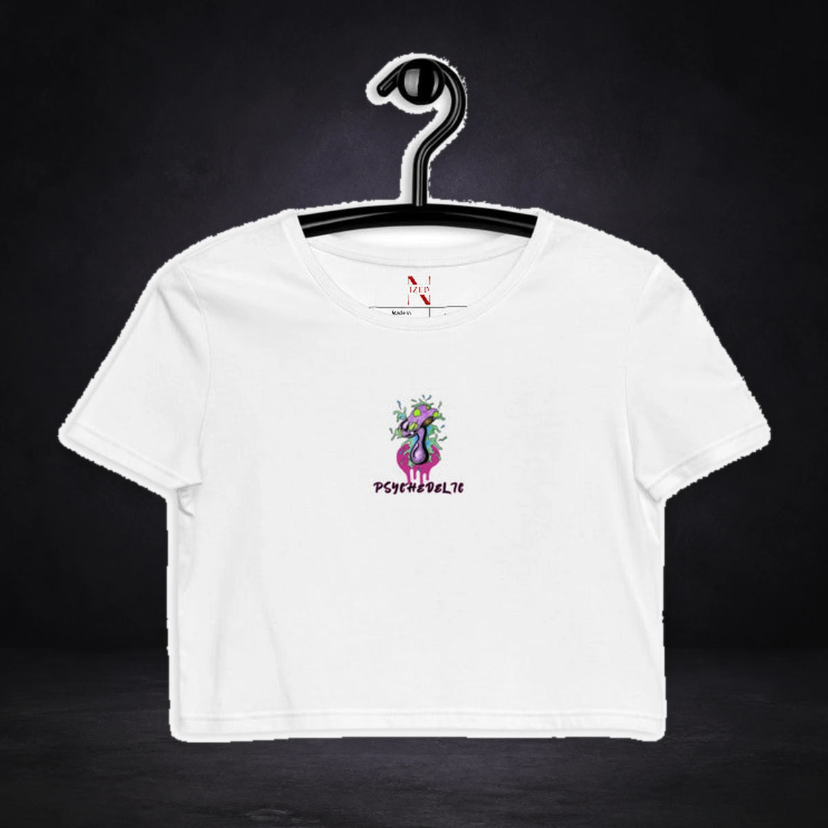 Psychedelic Crop Top von NiZED, Vorderansicht mit Designprint vor dunklem Betonhintergrund