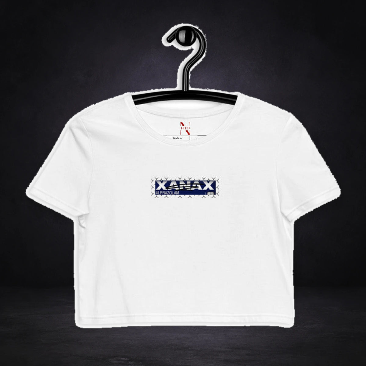 Xanax Alprazolam Crop Top von NiZED, Vorderansicht mit Designprint vor dunklem Betonhintergrund