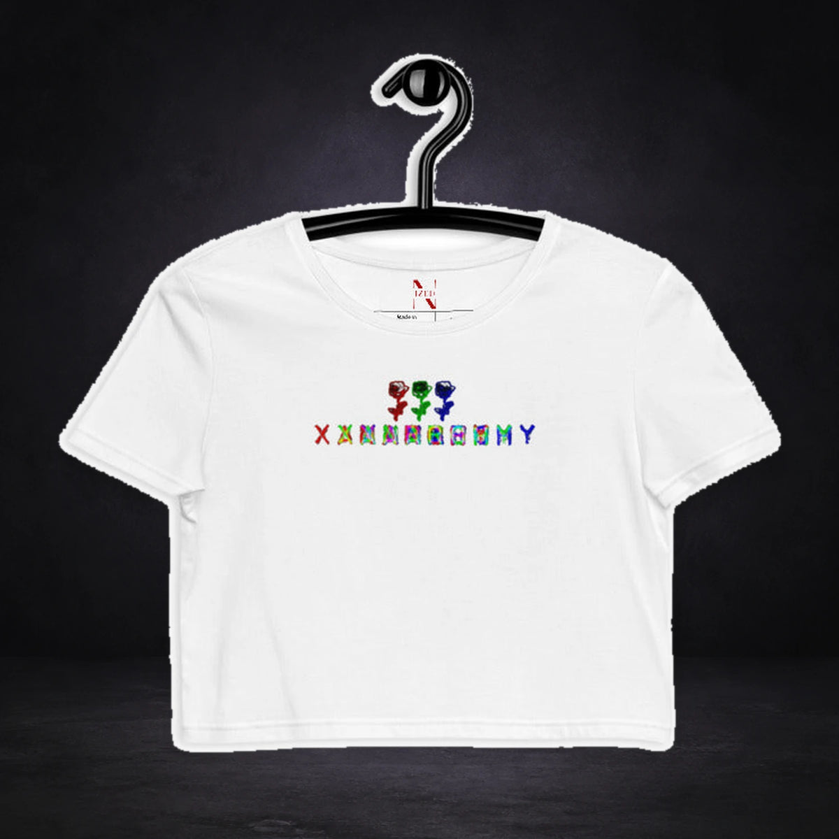 Xanax Anarchy Crop Top von NiZED, Vorderansicht mit Designprint vor dunklem Betonhintergrund