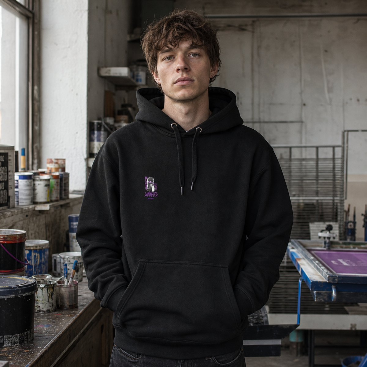 Nothing But Chaos Hoodie am männlichen Model mit Frontprint in einer Berliner Siebdruckwerkstatt – KI-generierte Darstellung