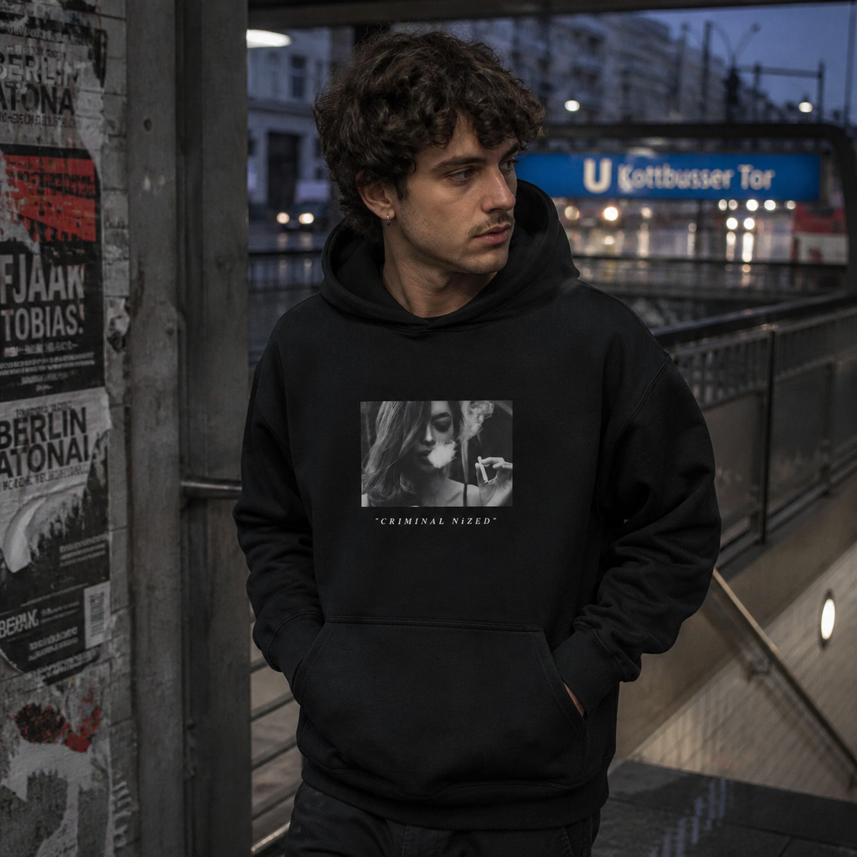 Numb Graphic Hoodie am männlichen Model mit Frontprint am Berliner U-Bahnhof – KI-generierte Darstellung