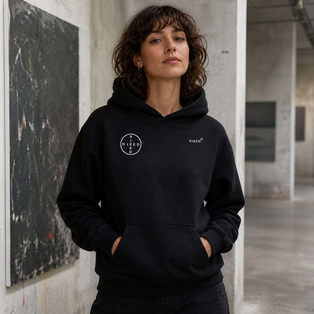 Origin Graphic Hoodie mit kleinen NiZED Brustprints an Frau – KI-generierte Darstellung