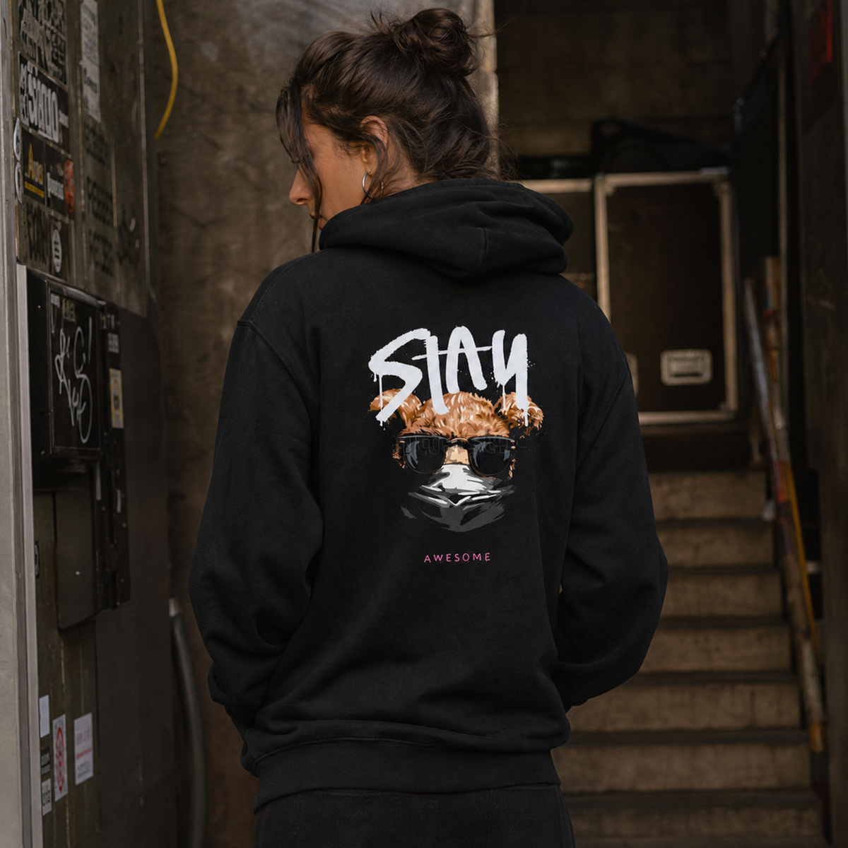 Stay Awesome Hoodie am weiblichen Model mit großem Backprint im Berliner Club-Treppenhaus – KI-generierte Darstellung