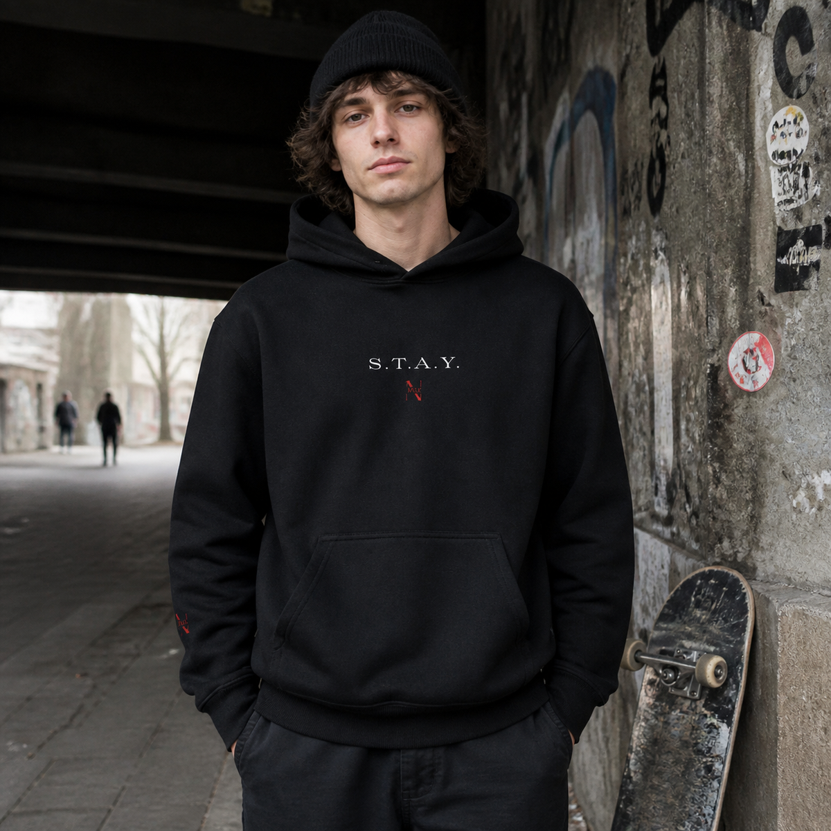 Stay Awesome Hoodie am männlichen Model mit Frontprint in einem Berliner Skate-Unterstand – KI-generierte Darstellung