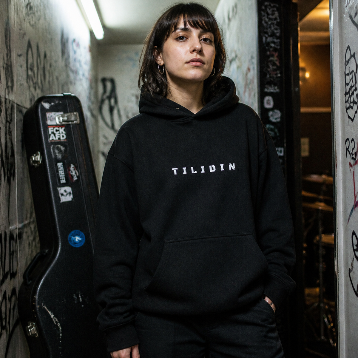 Tilidin Graphic Hoodie am weiblichen Model mit Frontprint im Berliner Bandkeller – KI-generierte Darstellung